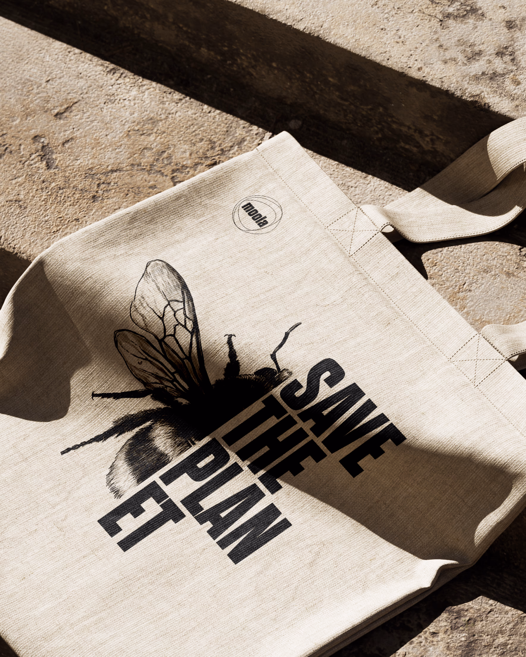 Moola-Jutebeutel mit Bienen-Illustration und dem Aufdruck „Save the Planet“ im Sonnenlicht
